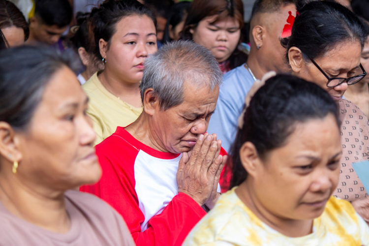 Seventy-one-year-old retired security guard Ramon Daanoy Jr. (in red) prays not just for a world free from disaster, but for some strength to find hope in recovery.