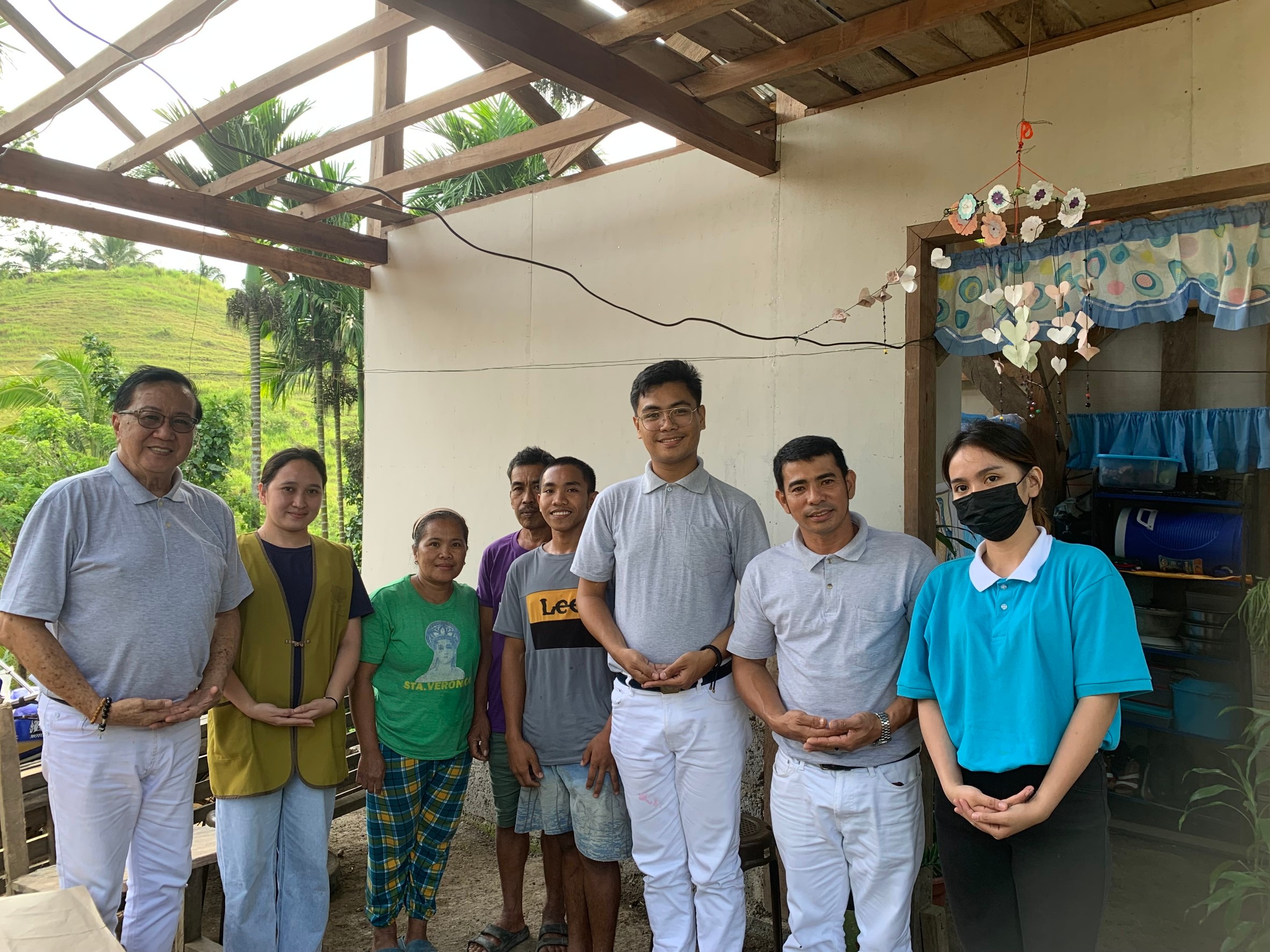 Going the extra-mile: Andrea Bonife Ibañez (in blue) and Tzu Chi volunteers Dhing Abdulaip, Eugene Tan, and Jerome Del Mundo trek uphill to reach families in remote mountain communities, leaving no one behind in their mission of service.