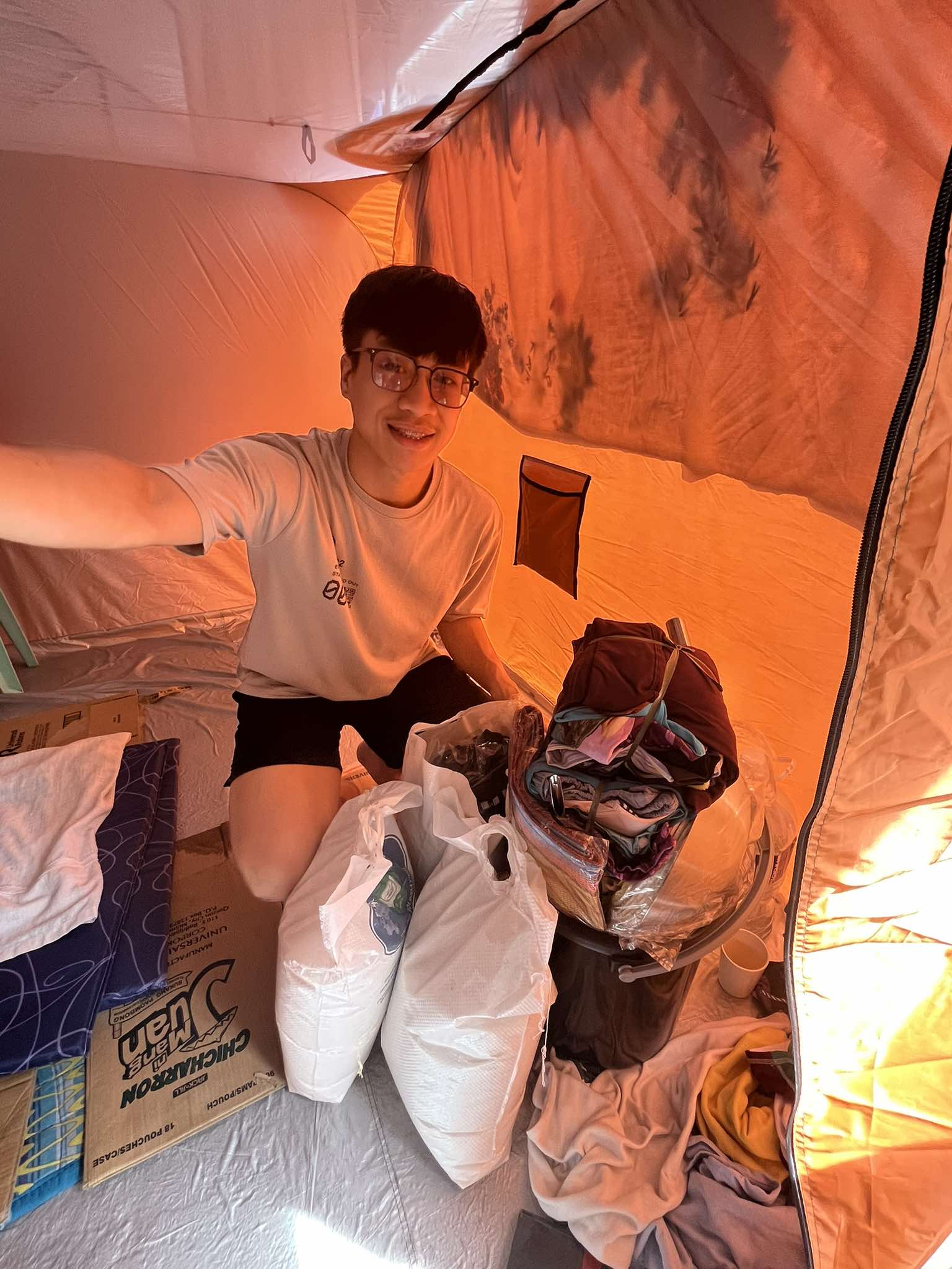 For Tzu Chi scholar Rainiel Manansala, home for now is a modular tent set up in his barangay’s multi-purpose court. To help him get back on his feet, Tzu Chi provided him with sacks of rice and essentials that include his scholar uniform. (Photo courtesy of Rainiel Manansala)