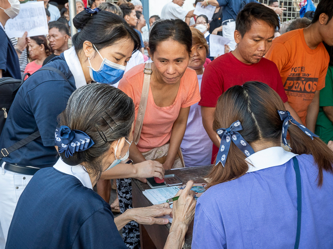 Tzu Chi volunteers check the beneficiary’s personal information during the stub distribution. 【Photo by Matt Serrano】
