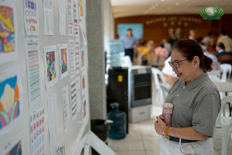 Helen Ong admires the artworks of the seniors. When choosing activities for their art sessions, the Tzu Chi volunteer makes sure the activities are fun, engage the senses, and stimulate brain activity.
