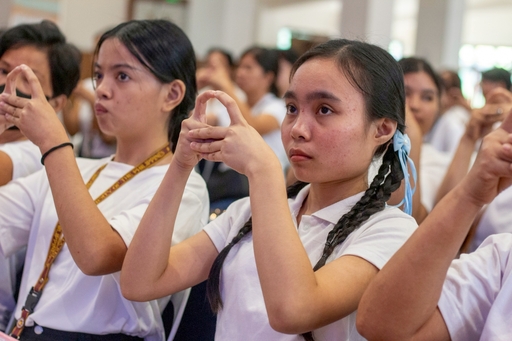 New scholars learn how to execute the hand gesture that accompanies the greeting “Amituofo” (“Immeasurable life”).