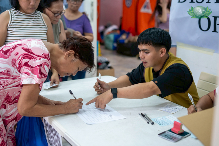 Representatives of the 29 families affected by the fire sign forms to receive relief from Tzu Chi.
