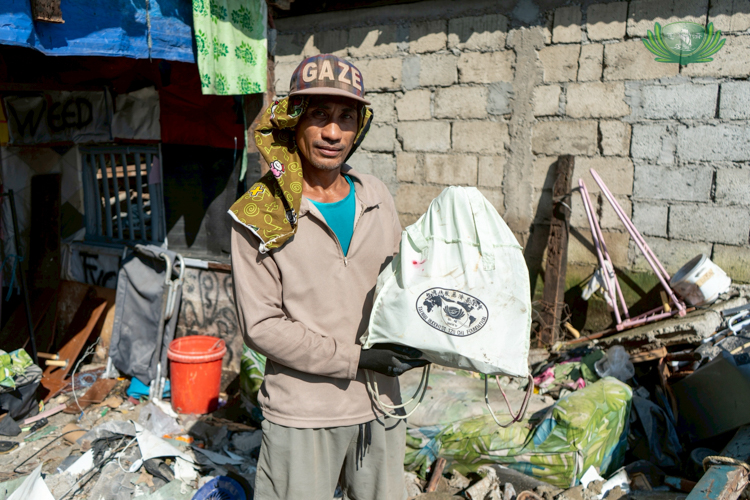 Harriz Danao, a former Tzu Chi beneficiary from Barangay Paltic, shows the relief bag he received from Tzu Chi during Typhoon Karding in 2023. He still uses the bag today.
