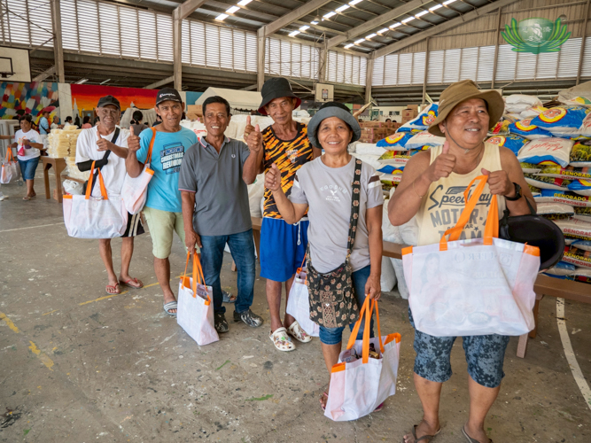 Senior citizens receive grocery items with smiles on their faces. They were given priority in line and were assisted by volunteers. 
