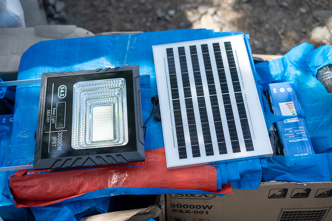 A solar panel provides light to households sheltered in outdoor tents. 