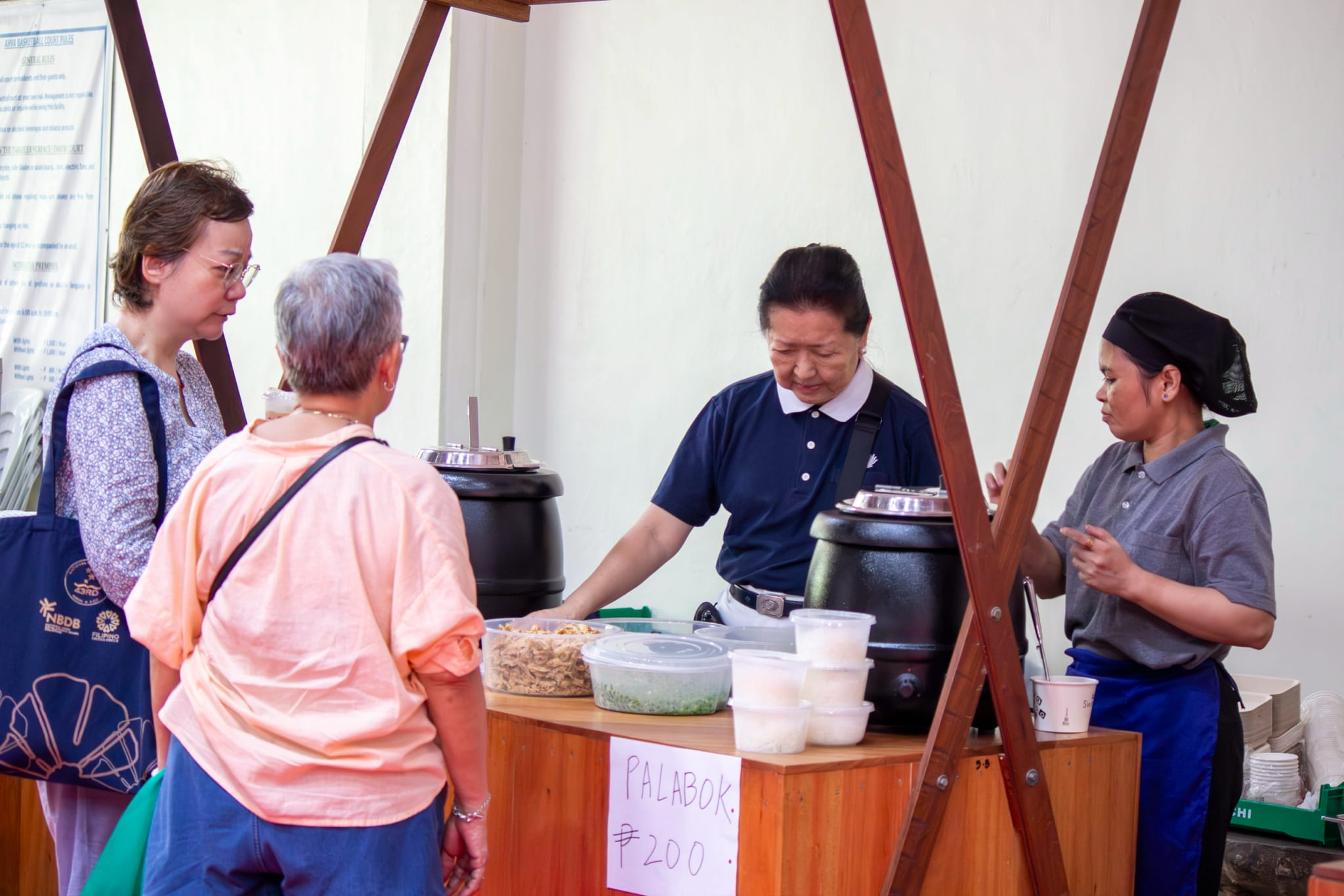 Tzu Chi volunteer Sally Yunez and staff introduce vegan food options to bazaar visitors.