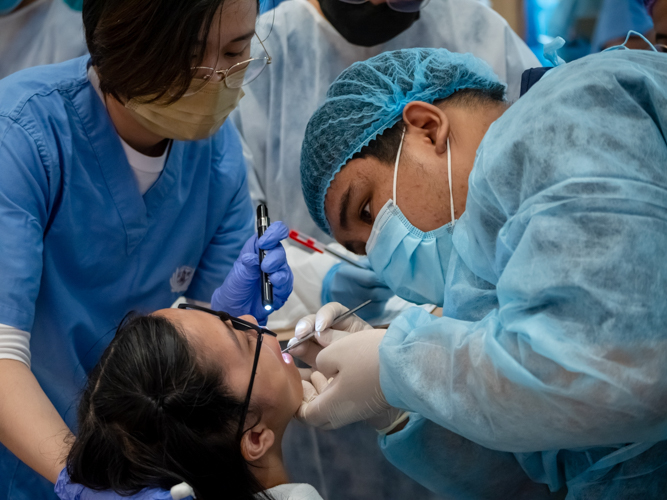 Dentists perform an oral exam on a Tzu Chi scholar. 【Photo by Daniel Lazar】