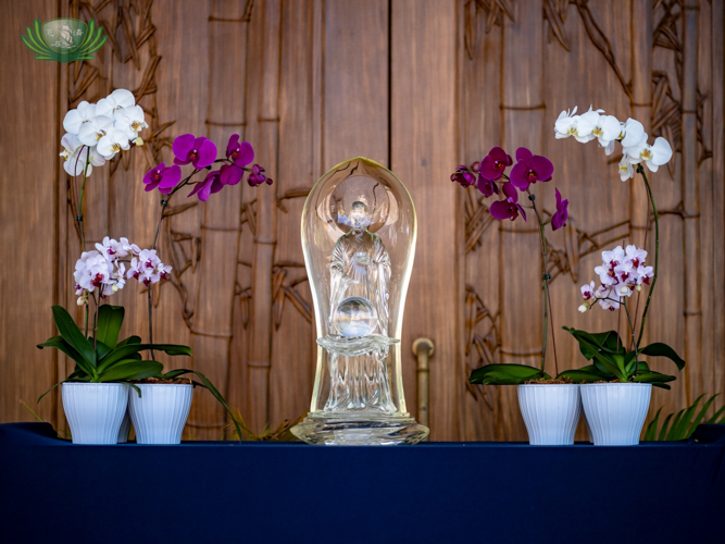 Flanked by orchids, a delicate crystal Buddha, flown in from Taiwan in time for the special occasion, was placed at the entrance of the Jing Si Auditorium. 【Photo by Daniel Lazar】
