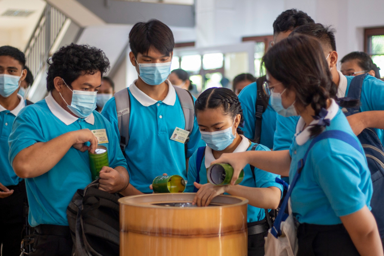 Dropping the coins they collected into a large coin back, Tzu Chi scholars become benefactors to people in need. 【Photo by Matt Serrano】