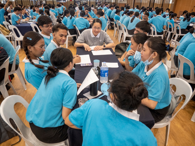 Tzu Chi volunteer Joy Gatdula (in gray) moderates a discussion among a group of scholars after an activity. 