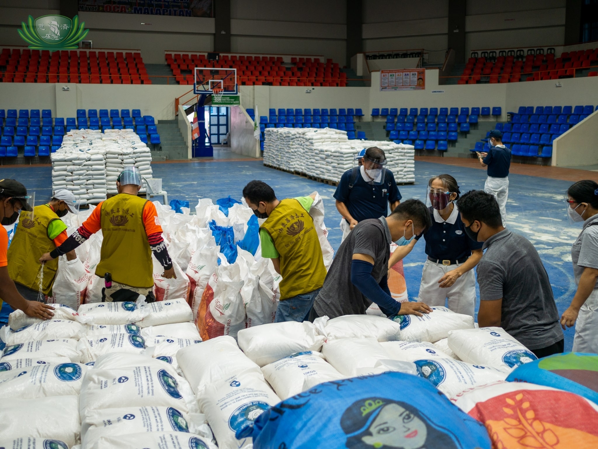 Tzu Chi volunteers prepare sacks of rice before beneficiaries come to claim them. 【Photo by Daniel Lazar】