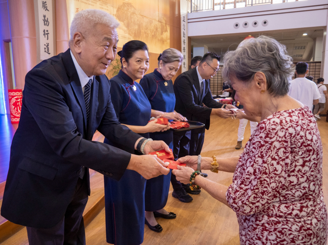 Tzu Chi Philippines CEO Henry Yuñez leads commissioners in the distribution of ampao containing commemorative coins from Dharma Master Cheng Yen.