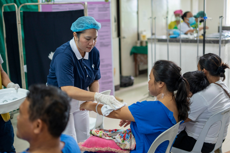 In a show of compassion, Tzu Chi volunteers help clean patients up post-surgery.