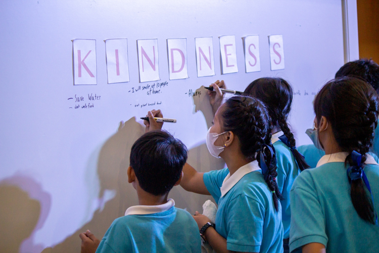 Tzu Chi scholars approach the white board to write the acts of kindness they can commit to. 【Photo by Marella Saldonido】
