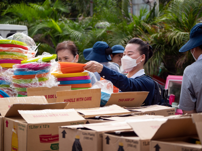 A volunteer sets up plates for distribution. 【Photo by Daniel Lazar】