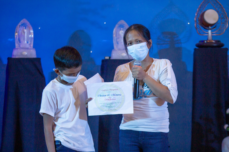 Cecil Memoria (right) accepts a certificate declaring her son Christian a Cancer Survivor. With his treatments over, Cecil has decided to end Tzu Chi’s medical assistance for her son “so that others may receive help for their conditions,” she says.  【Photo by Marella Saldonido】