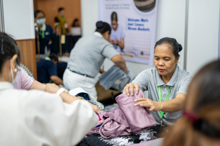 At the Waste to Wonder booth, Lina Lajara assists shoppers. A Tzu Chi volunteer since 2013, she participates in the foundation’s upcycling program, weaving floor mats and stool covers with the excess material of sports socks. 