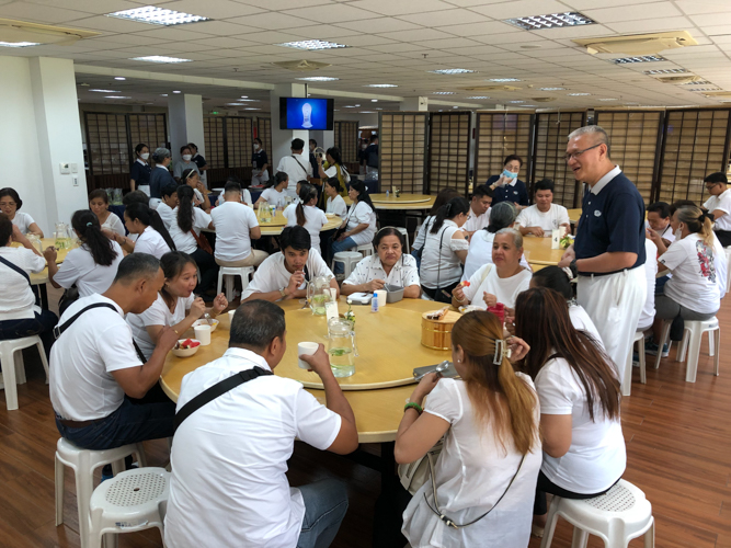 Parents of scholars enjoy snacks at Harmony Hall before surprising their children at the Jing Si Auditorium.