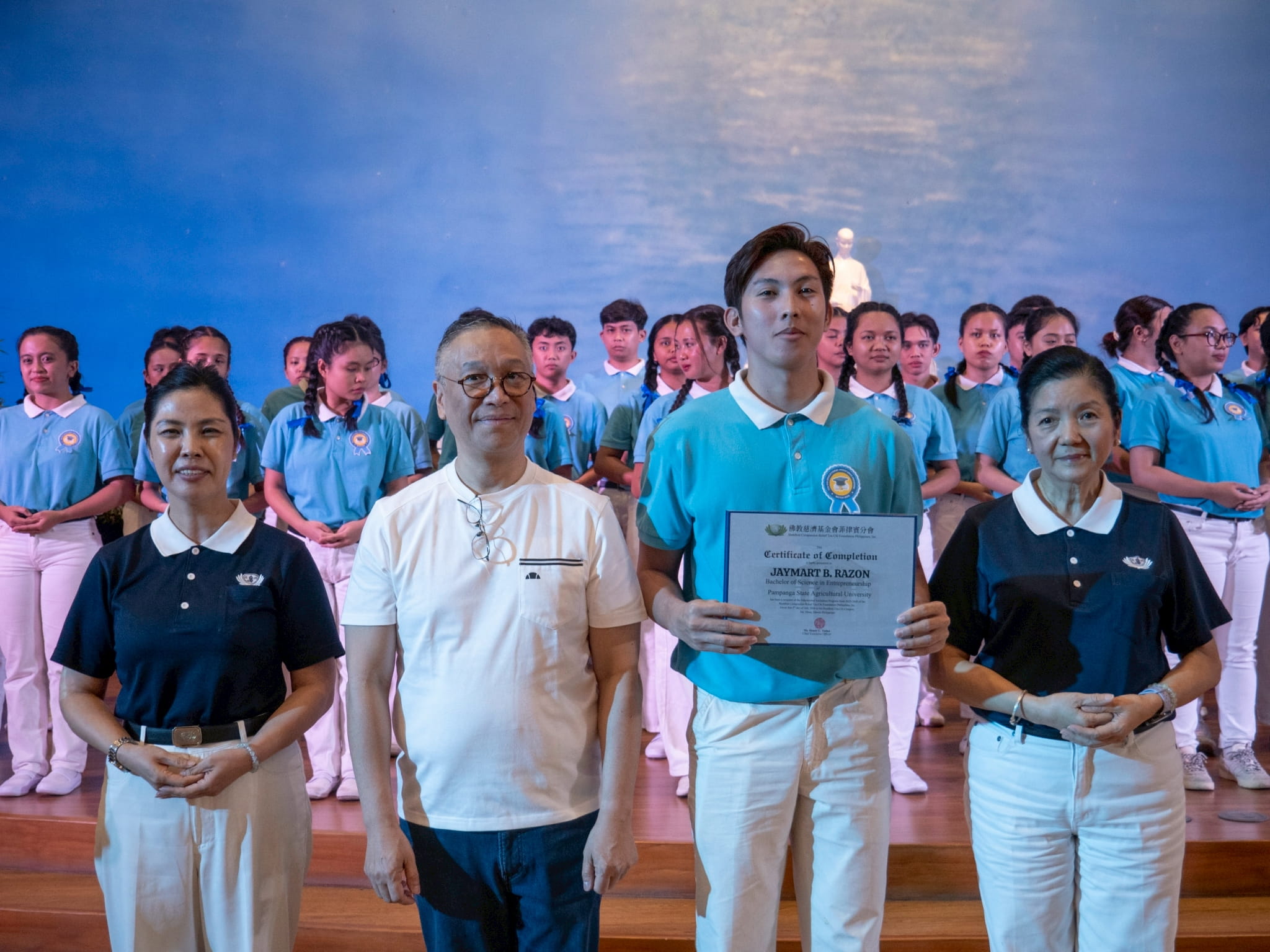 Regan Industrial Sales, Inc. CEO Regan Sy (second from left) participates in presenting scholars with their certificates. He is joined by Tzu Chi Pampanga volunteer Pansy Ho (left) and Rosa So, head volunteer for the educational and medical assistance programs (right).