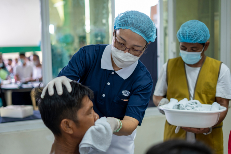 In a show of compassion, Tzu Chi volunteers help clean patients up post-surgery.