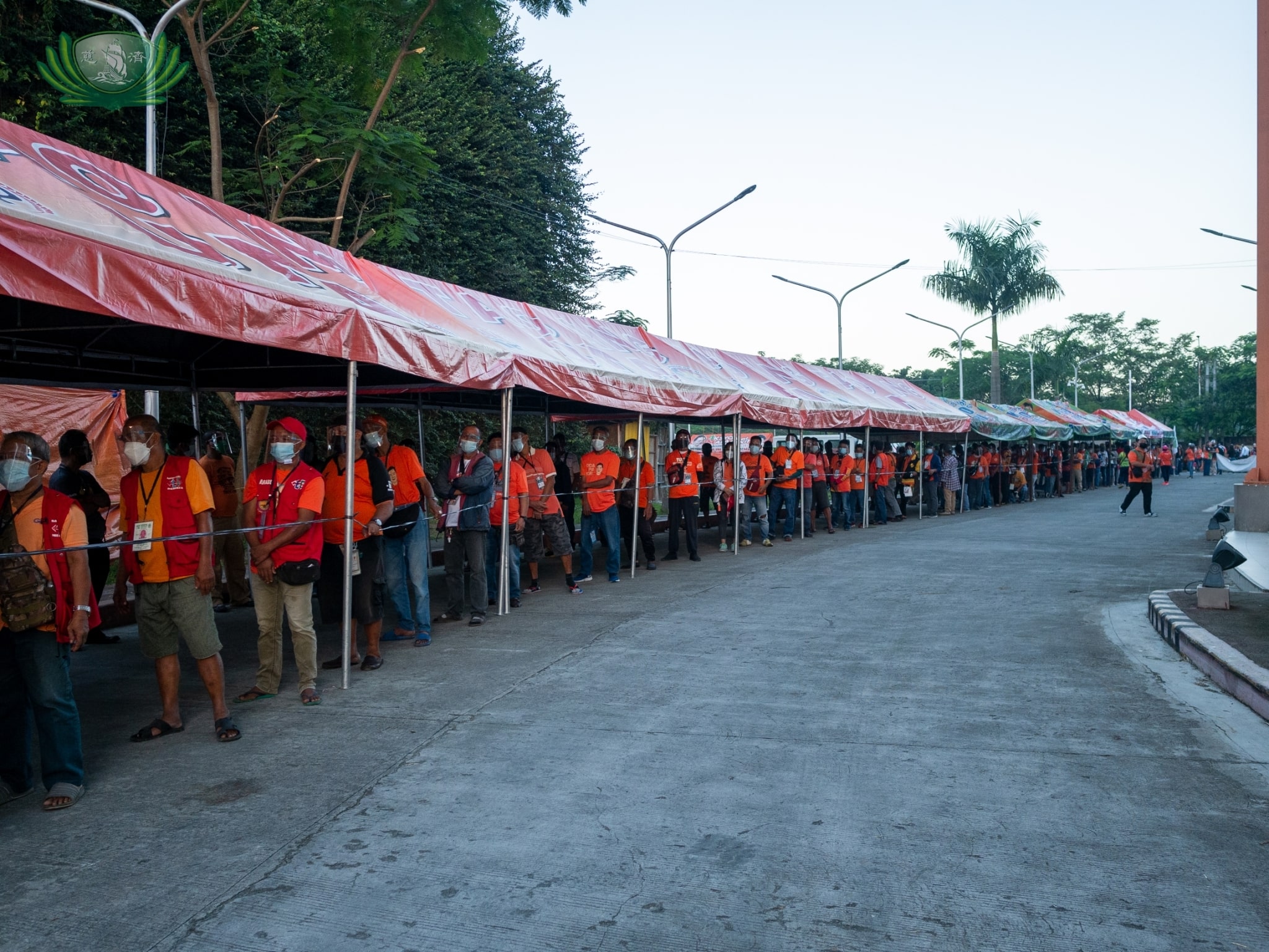 Caloocan North’s 2,721 tricycle drivers wait patiently in line along the driveway of the Caloocan Sports Complex. 【Photo by Daniel Lazar】 