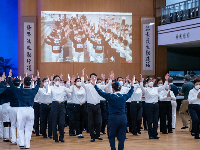 Tzu Chi commissioners and videos of past Lotus Sutra Adaptation performances guide volunteers during rehearsals. 【Photo by Daniel Lazar】
