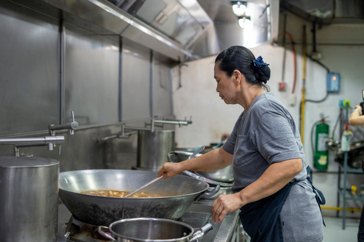 At Harmony Hall’s kitchen, a staffer checks on her cooking. 