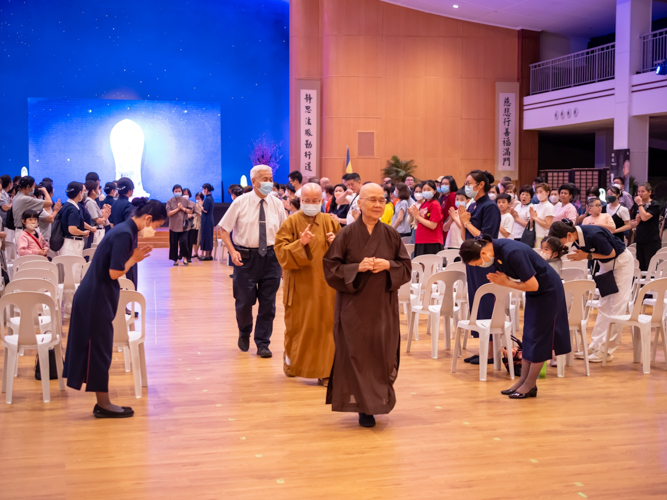Tzu Chi volunteers bow in gratitude as the Buddhist monks exit the Jing Si Auditorium following their viewing the sutra adaptation. 【Photo by Daniel Lazar】