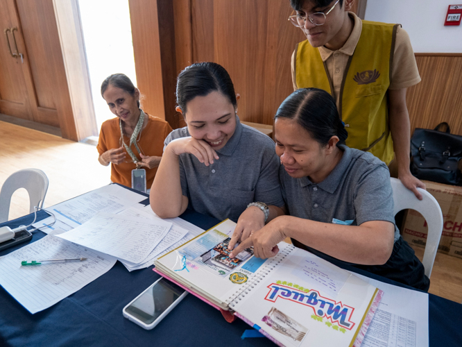 Tzu Chi volunteers reminisce as they look through the photo album of Gelly Mancera (first from left), mother of scholar Miguel Gero Mancera. 