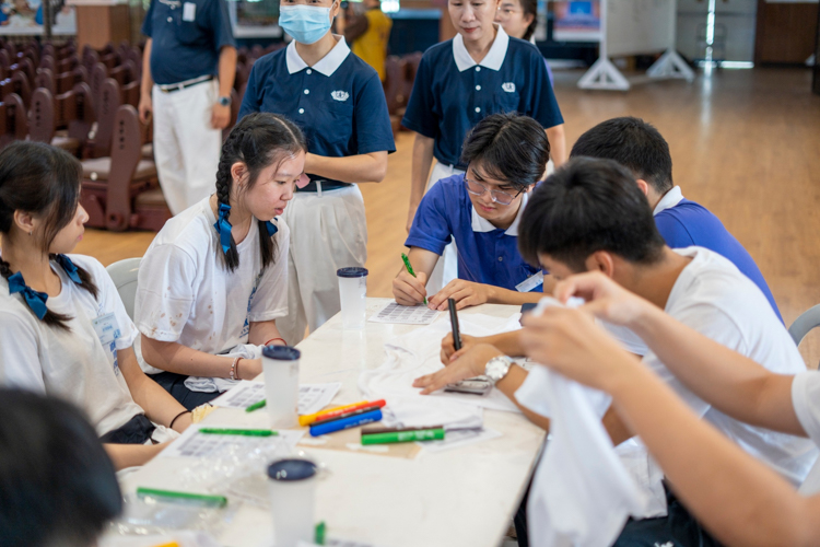 Inside the Jing Si Hall, groups are given plain T-shirts and colorful markers to design their shirts as they please. 