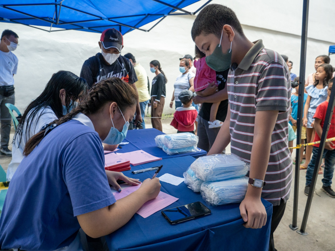 A member of Tzu Chi Youth (seated, in blue) helps with registration. 【Photo by Matt Serrano】