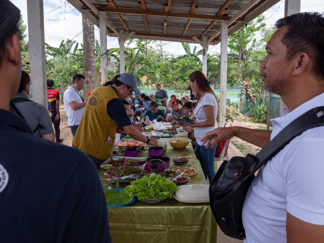 Tzu Chi volunteers and members of Quezon City’s Sustainable Development Affairs enjoy a plant-based lunch of veggies sourced from the New Greenland Community Model Farm.【Photo by Daniel Lazar】