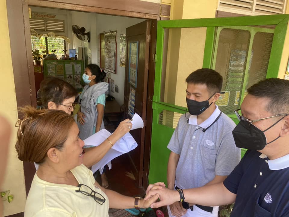 Zamboanga volunteers Dr. Anton Mari Lim (rightmost) and Harvey Yap (center) talk to Barangay Kagawad Marisa Mariano (leftmost) during Tzu Chi’s relief mission in Divisoria Elementary School.