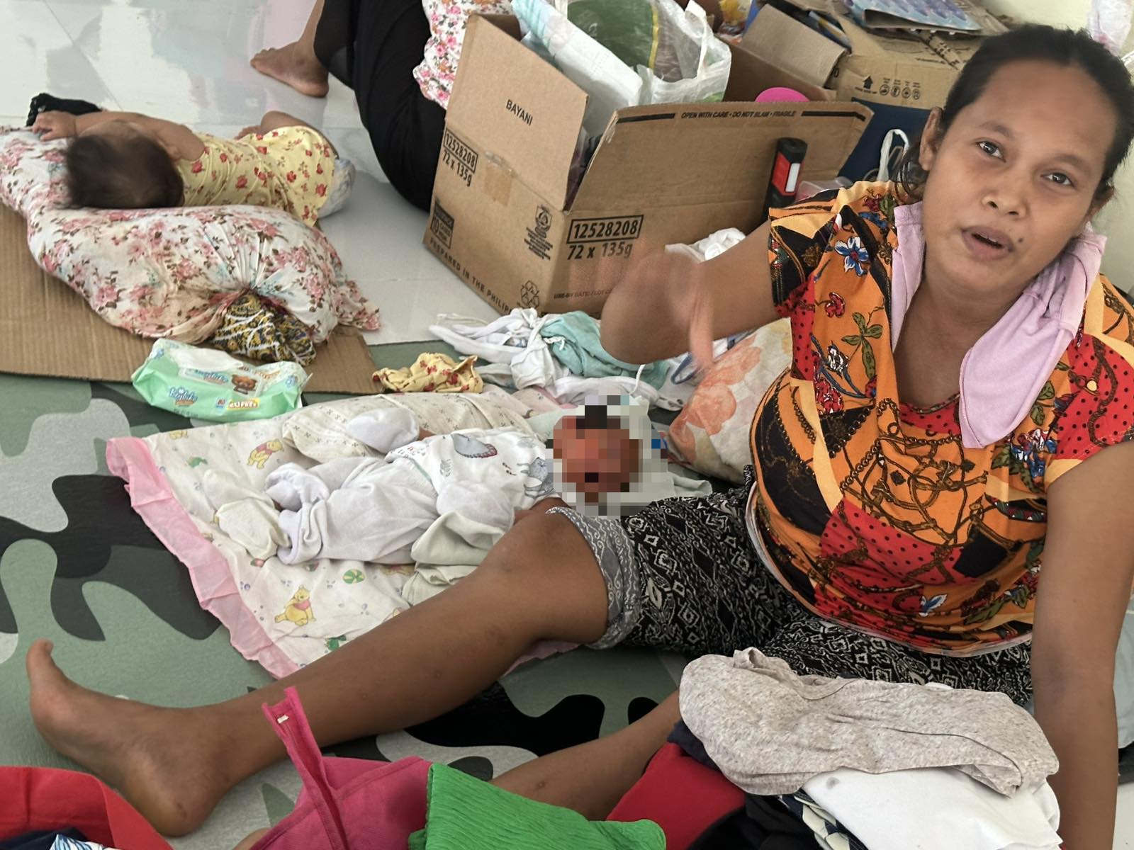 Marites Bellones, who gave birth during the typhoon, currently recovers at the PagCor Multi-purpose Evacuation Center in Bula, Camarines Sur.