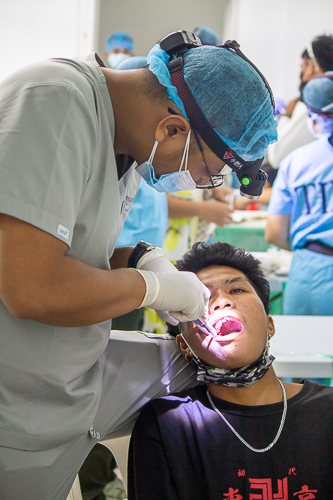 A volunteer dentist extracts a patient’s tooth. 【Photo by Marella Saldonido】