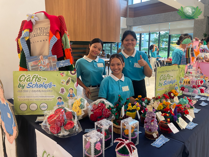 Tzu Chi scholars proudly pose beside their creative booth at Fiesta Verde 2025.