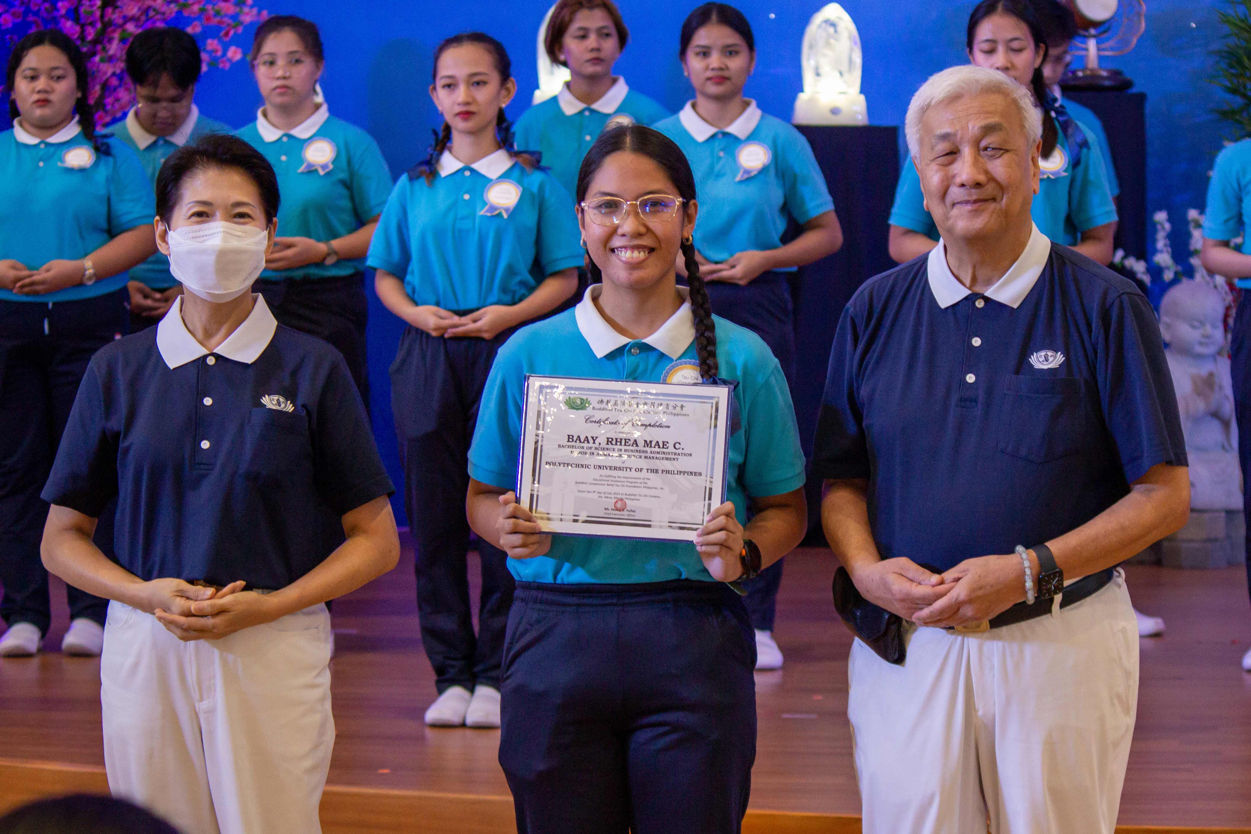 Rhea Mae Baay receives her certificate of completion from Tzu Chi Philippines CEO Henry Yuñez (right) and Deputy CEO Woon Ng (left). 【Photo by Marella Saldonido】