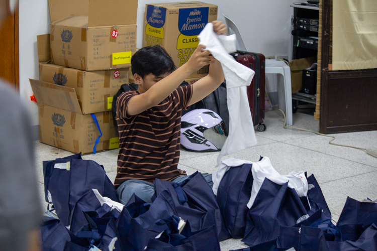 One of the roles of the logistics committee is checking the bags to ensure that items such as shirts are properly packed.