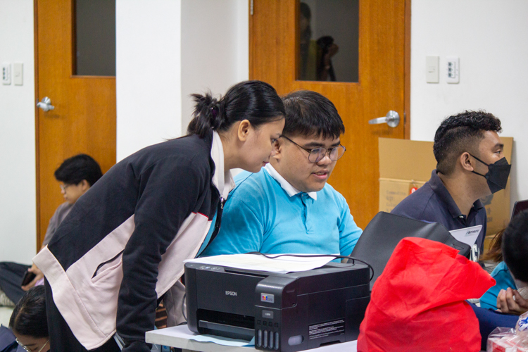 2024 Tzu Chi Scholars’ Camp Head Paolo Nicole Santos (center) coordinates with team members for the camp preparations.