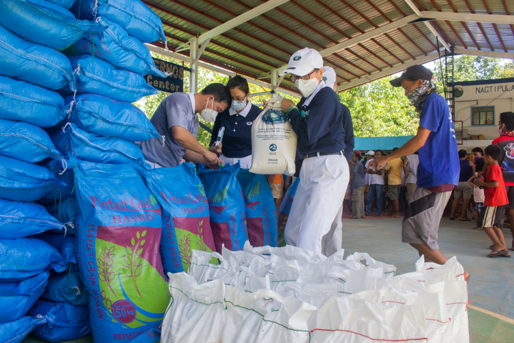 Local and Tzu Chi volunteers helping unload rice.【Photo by Daniel Lazar】