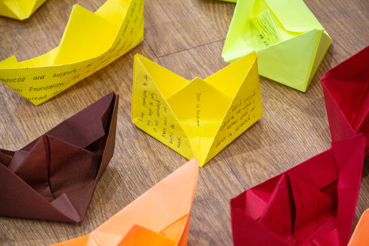 After writing letters to themselves, scholars fold their papers into a boat and place them in a candle-lined space, while others hang their leaf-shaped letters on tree branches. 