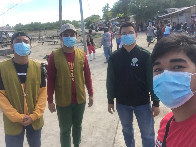 Karwin Hamjani (2nd to the left) and Munadzrin Ipah (2nd to the right) together with other volunteers during a relief distribution in Zamboanga. 【Photo by Harold Alzaga】