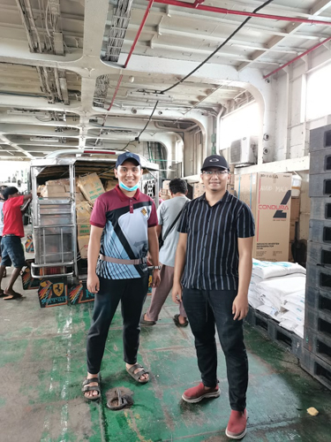 Volunteers Karwin Hamjani and Munadzrin Ipah during a relief distribution in Zamboanga. 【Photo by Harold Alzaga】