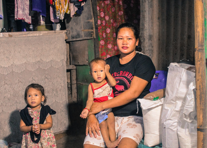 Now part of Tzu Chi’s relief distributions in Montalban, Rizal, scavenger Lia Albano (seen here with her kids) is happy to have “something to eat. We don’t earn much from scavenging.” 【Photo by Don Lopez】