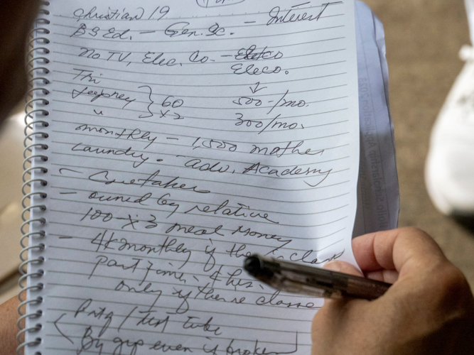A volunteer takes notes on a scholar-applicant’s monthly expenses. 【Photo by Matt Serrano】