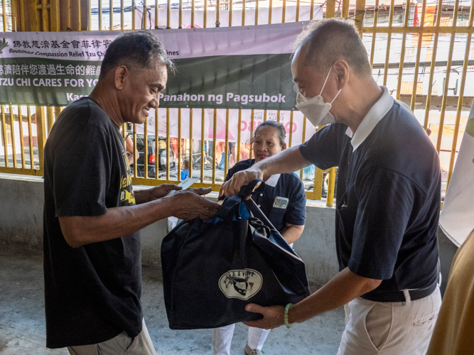 Beneficiaries of the Fire Relief Operations in Brgy. Tumana, Marikina receive the relief goods prepared by the ISM middle school students. 【Photo by Matt Serrano】
