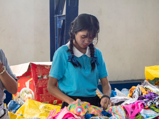 Tzu Chi scholar Ma. Vera Clarisse Santos was assigned to the clothing section of the bazaar. 【Photo by Matt Serrano】