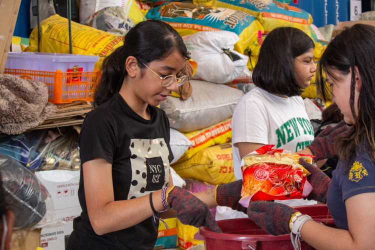 ISM students carefully prepare each bucket with essential items for the relief packages. 【Photo by Marella Saldonido】