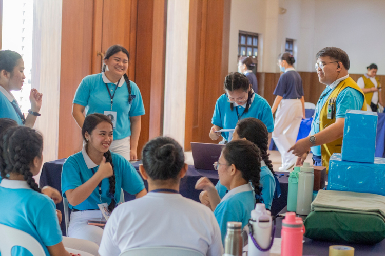 Scholars who volunteered as working personnel enjoy a fun time dancing to the camp song while taking a break.